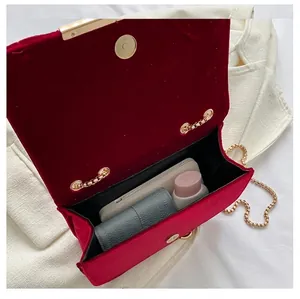 Red velvet crossbody bag with gold chain showing internal storage capacity