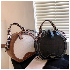 Detail of crocodile pattern PU leather bag with checkered scarf wrapped handle