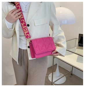 Detail of rose pink quilted crossbody bag with stylish yellow patterned wide strap