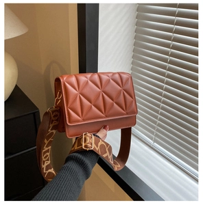 Detailed view of caramel quilted shoulder bag with patterned jacquard wide strap