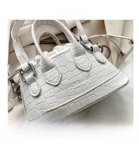 Close-up of white crocodile texture mini handbag with silver metal hardware and buckle
