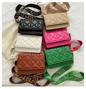 Close-up of quilted diamond pattern small square bags in six colors with woven straps