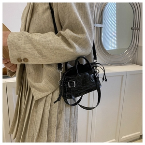 Detail of black crocodile pattern mini handbag with adjustable thin shoulder strap