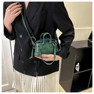 Detail of dark green crocodile texture mini crossbody bag with drawstring liner