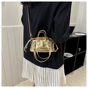 Detail of gold crocodile embossed mini bag with drawstring lining and fashion text