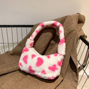 Plush faux fur underarm bag featuring a white base with pink heart patterns