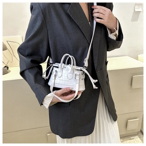 Detail of white crocodile texture mini bag with drawstring lining and crossbody strap