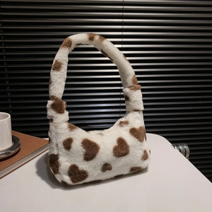 Fuzzy cream tote bag with brown heart patterns shown in a cozy lifestyle setting