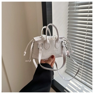 Close-up of white crocodile pattern handbag with drawstring inner bag and logo detail