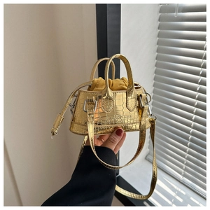 Detail of gold crocodile embossed mini handbag with drawstring liner and fashion logo