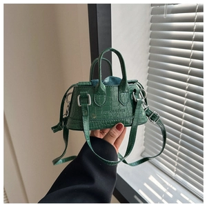 Close-up of deep green crocodile texture mini handbag with Fashion & Bags embossing