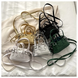 Detailed close-up of mini croc-embossed boston bags in gold, silver, white, green and black