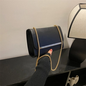Bolso bandolera de cuero negro chic con barra metálica dorada y correa de cadena