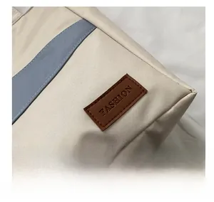 Detail der Oxford-Stofftasche mit blauem Streifen und braunem Leder-FASHION-Patch