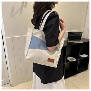 Detail of Oxford canvas tote bag featuring geometric patchwork and fashion leather label