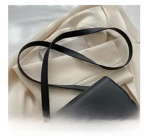 Gros plan d'un sac à bandoulière noir avec un fermoir rotatif doré en forme de cœur