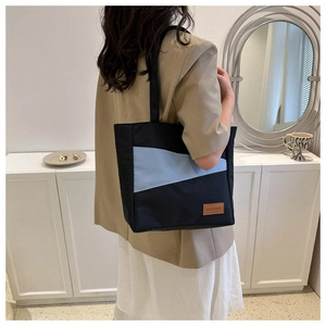 Fashionable Oxford cloth shoulder bag with blue patchwork and a stylish logo label detail