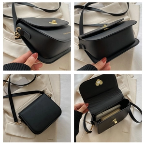 Détails du sac bandoulière noir montrant l'espace intérieur et le fermoir doré tournant