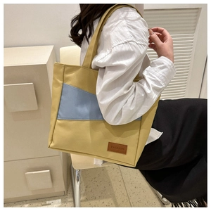 Detail of large ginger yellow and blue oxford fabric tote bag with leather fashion tag