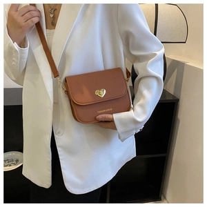 Détail d'un sac bandoulière en similicuir marron avec fermoir coeur doré et texte gravé