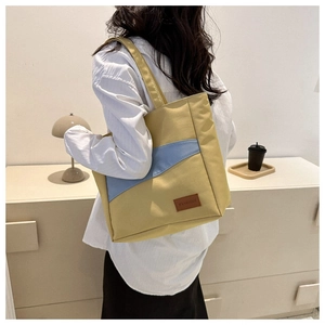 Detail of high-capacity oxford tote bag with contrast yellow and blue panel design