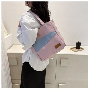 Pink and light blue canvas tote bag with leather FASHION patch shown on model's shoulder