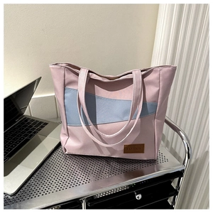 Close-up of pink and blue canvas tote bag with fashion tag on a metal shelf