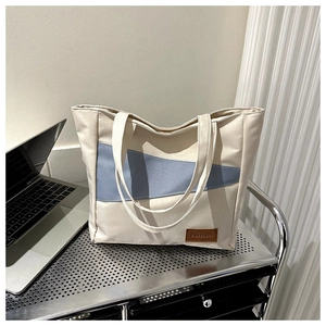 Detail of the high-capacity oxford tote bag with two-tone splicing and fashion leather tag