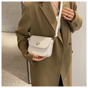 Détail du sac bandoulière en cuir PU blanc avec fermoir rotatif en métal doré en cœur
