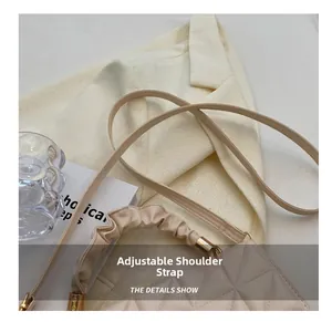 Détail du sac bandoulière beige matelassé avec poignée froncée et bandoulière réglable