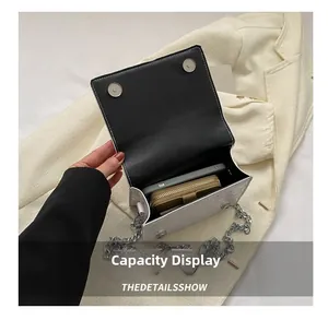 Detail showing internal capacity of the white crocodile pattern chain bag for storage