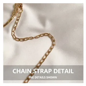 Detail of golden chain strap with a delicate metal flower carving on white fabric