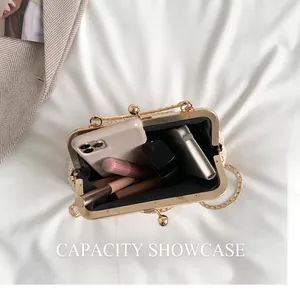 Detail view of woven straw clutch capacity showing interior space with gold chain strap