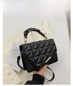 Détail du sac à bandoulière noir matelassé avec poignée plissée et boucle en métal doré