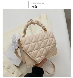 Détail du sac matelassé blanc cassé avec poignée plissée et fermoir en métal doré