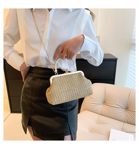 Close-up of retro straw handbag featuring a gold metal frame and chain shoulder strap