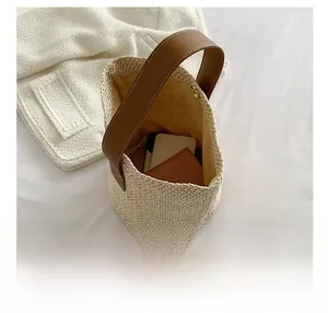 Internal view of beige woven bucket bag showing spacious storage with metal magnetic clasp