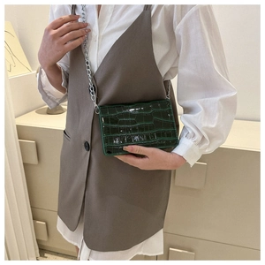Close-up of a dark green crocodile pattern PU leather crossbody bag with silver chain