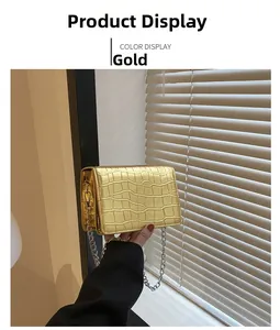 Detail of gold faux leather handbag with crocodile pattern and silver chain strap