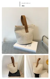 Detail of rice white woven bucket bag featuring brown leather handle and natural texture