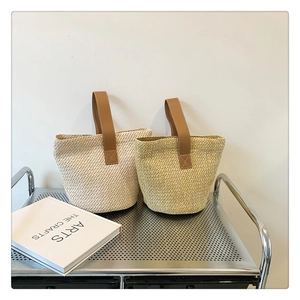 Detailed texture of straw woven bucket bags in beige and yellow with leather handles