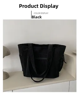 Détail d'un grand sac fourre-tout noir en velours côtelé avec poches latérales et zip