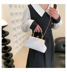 Chic white tweed handbag with gold metal handle and chain strap on a stylish background