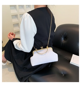 Detailed texture of white tweed bag with gold metal handle and vintage clasp lock