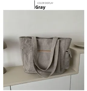 Détails du sac à bandoulière en velours côtelé gris avec grandes poches à l'avant