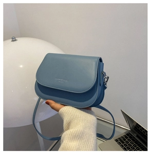 Detail of grey-blue crossbody bag featuring FASHION & BAG lettering and silver metal buckle