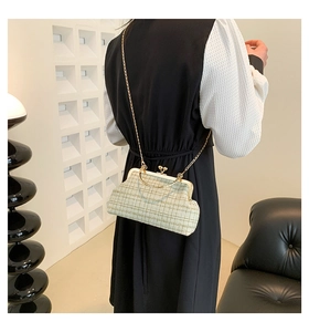 Detail of cream tweed chain crossbody bag with metallic frame and textured weave finish