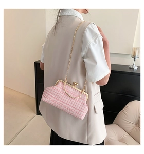 Pink and white tweed shoulder bag with golden metal chain shown in a lifestyle setting