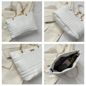 Detail view of white quilted tote bag showing spacious interior and golden chain straps
