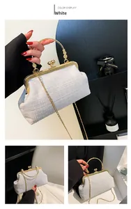 Detailed view of a white tweed shell bag with gold bead handle and spherical clasp